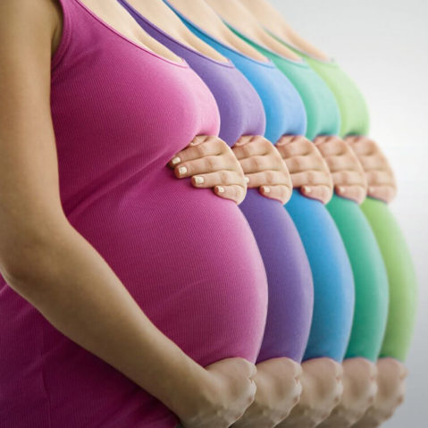 Powielony obraz kobiety w ciąży. W każdej wersji kobieta ma koszulkę w innym kolorze.