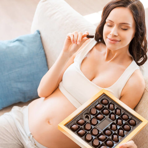 Kobieta w ciąży je czekoladki