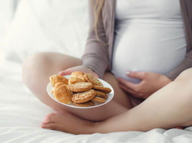 Kobieta w ciąży z ciastkami